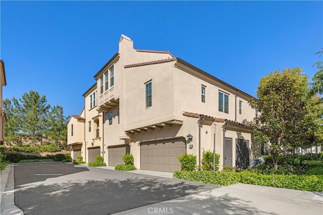 65 Tallowood, Irvine, CA 92620 - view of home's exterior with stucco siding, a garage, driveway, and a chimney