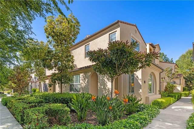 65 Tallowood, Irvine, CA 92620 - view of side of home featuring stucco siding