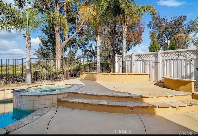 view of pool featuring an in-ground hot tub, fence, and a patio