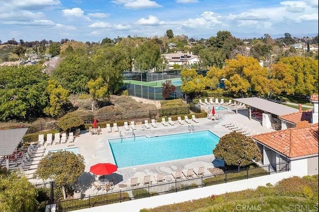 community pool featuring fence and a patio area