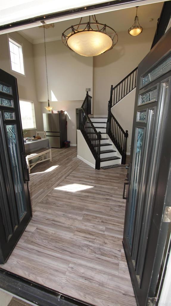 42944 Calle Reva, Temecula, CA 92592 - foyer featuring a towering ceiling, stairway, light wood-type flooring, crown molding, and baseboards
