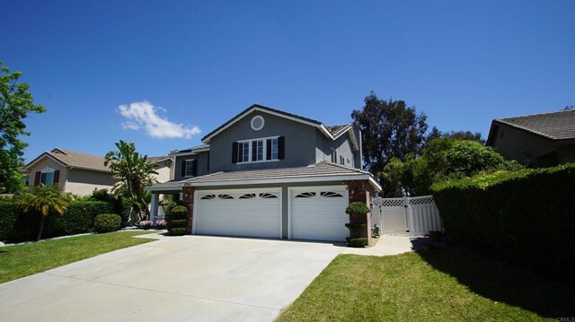 42944 Calle Reva, Temecula, CA 92592 - traditional-style house with an attached garage, driveway, stucco siding, and a gate