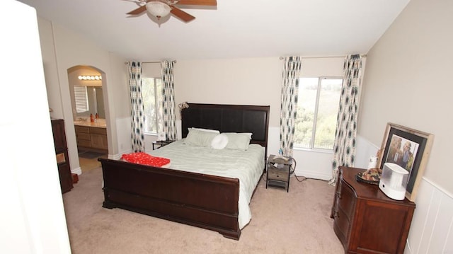 42944 Calle Reva, Temecula, CA 92592 - bedroom featuring arched walkways, light carpet, a wainscoted wall, ensuite bathroom, and a ceiling fan