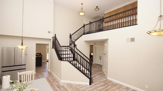 42944 Calle Reva, Temecula, CA 92592 - stairway with wood finished floors, a towering ceiling, and baseboards