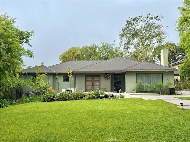 view of front of home with stucco siding, french doors, and a front yard