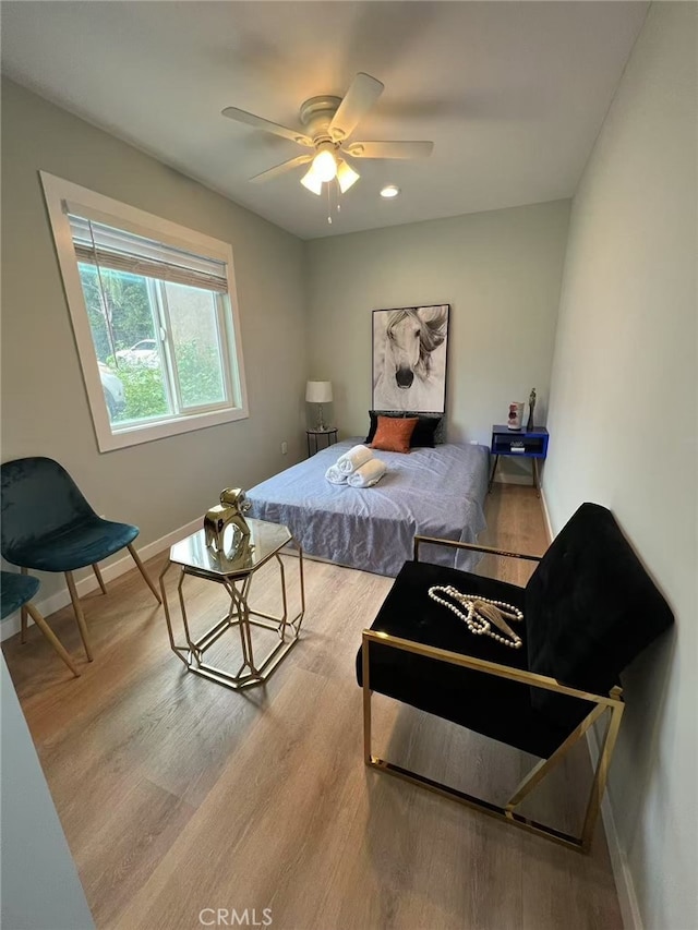 bedroom with baseboards, ceiling fan, and wood finished floors