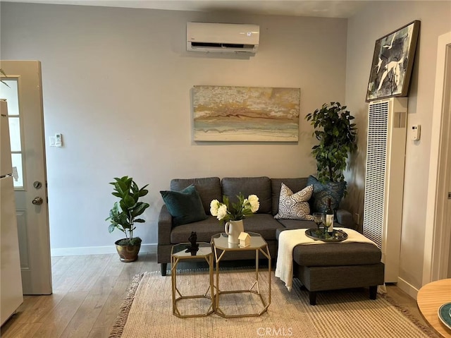 living area with wood finished floors, baseboards, a wall mounted air conditioner, and a heating unit