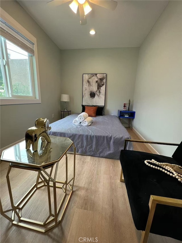 bedroom with baseboards, a ceiling fan, and wood finished floors