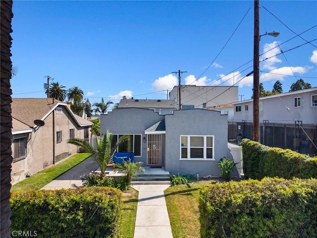 844W 105th St, Los Angeles, CA 90044 - view of front of property featuring fence, stucco siding, and a patio