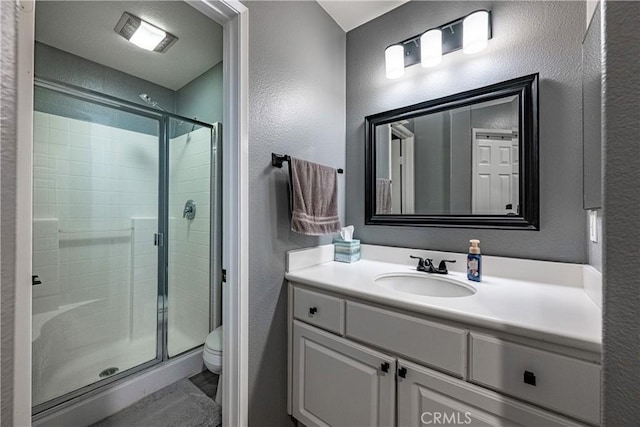 7 Burlingame Ln, Aliso Viejo, CA 92656 - bathroom featuring a textured wall, toilet, a stall shower, and vanity