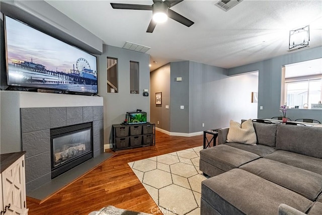 7 Burlingame Ln, Aliso Viejo, CA 92656 - living area with wood finished floors, a ceiling fan, a tiled fireplace, and baseboards