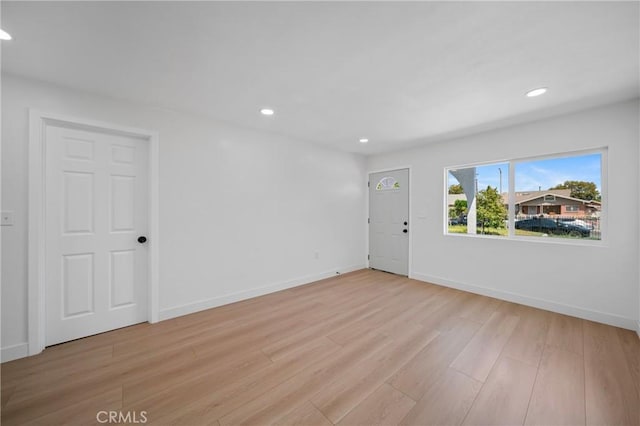 unfurnished living room featuring recessed lighting, baseboards, and light wood-style floors