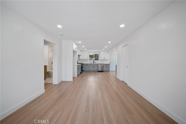 unfurnished living room featuring baseboards, recessed lighting, and light wood-style flooring