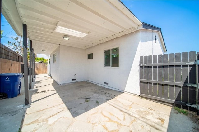 view of patio featuring fence and an attached carport