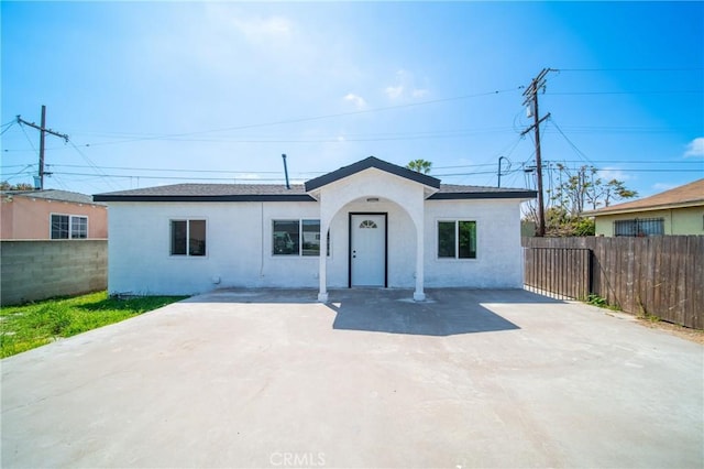 ranch-style home with stucco siding and fence