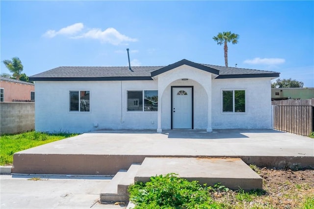 view of front of home with fence, a patio, and stucco siding