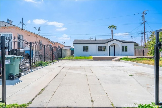 ranch-style home featuring fence, stucco siding, and driveway