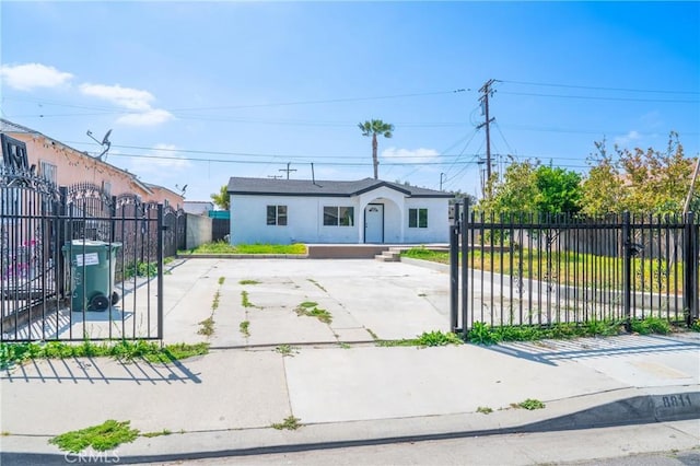 view of front of house with a gate, a fenced front yard, and stucco siding