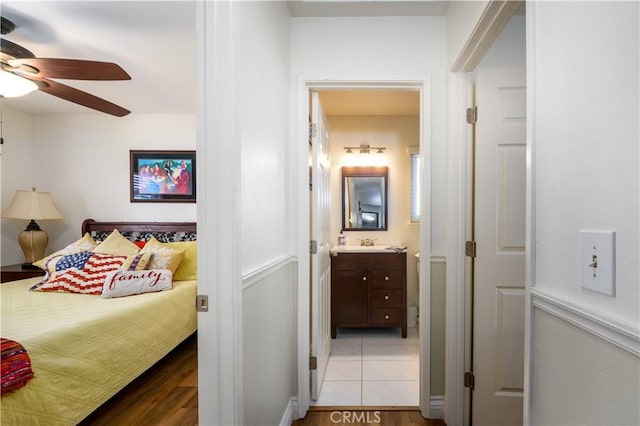 bedroom featuring a sink, connected bathroom, ceiling fan, and light tile patterned flooring