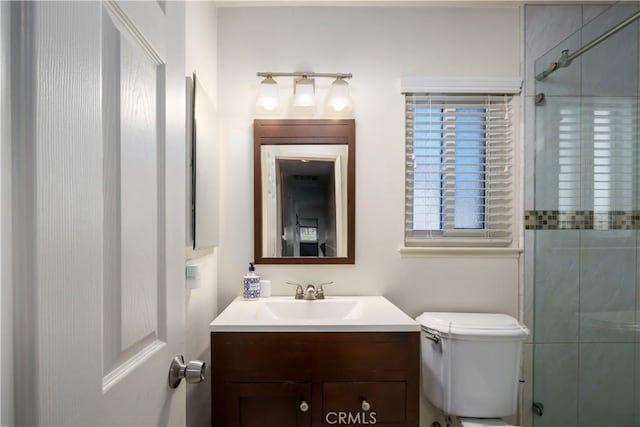 full bathroom with a shower with shower door, vanity, and toilet