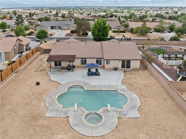 view of pool featuring an in ground hot tub, a residential view, a fenced backyard, a patio, and a water slide