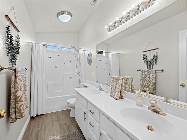 bathroom with double vanity, a sink, wood finished floors, and toilet
