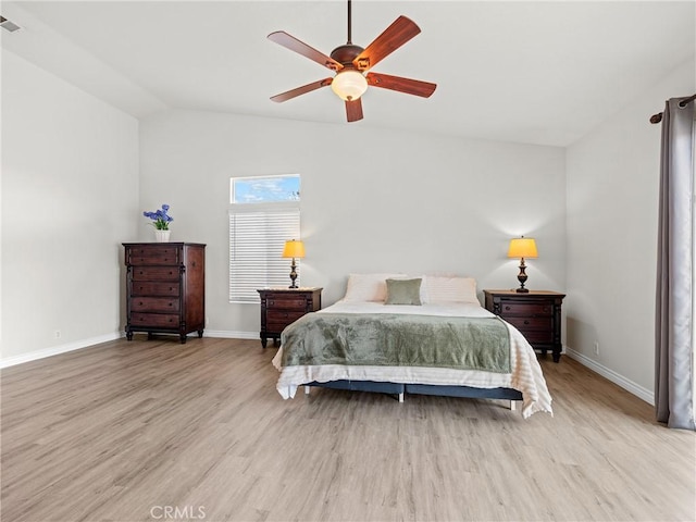 bedroom with baseboards, light wood-style flooring, and lofted ceiling