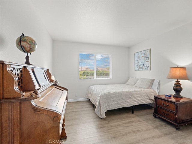 bedroom with baseboards and light wood-style flooring