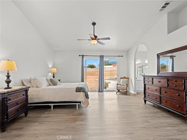 bedroom featuring arched walkways, visible vents, light wood finished floors, and access to exterior