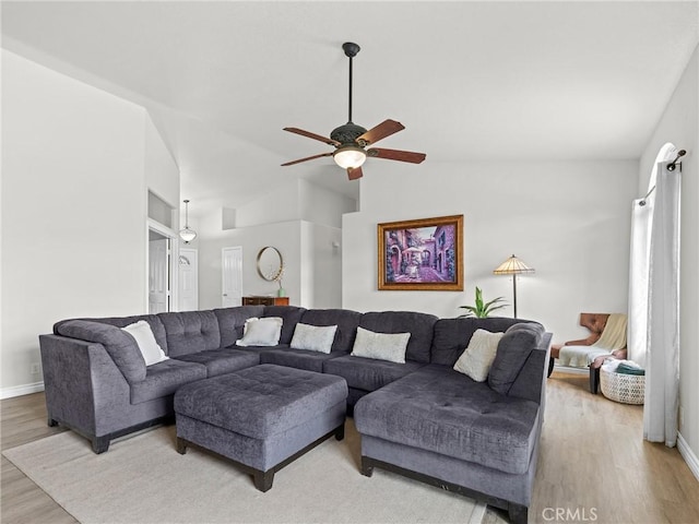 living room with a ceiling fan, baseboards, light wood-style flooring, and lofted ceiling