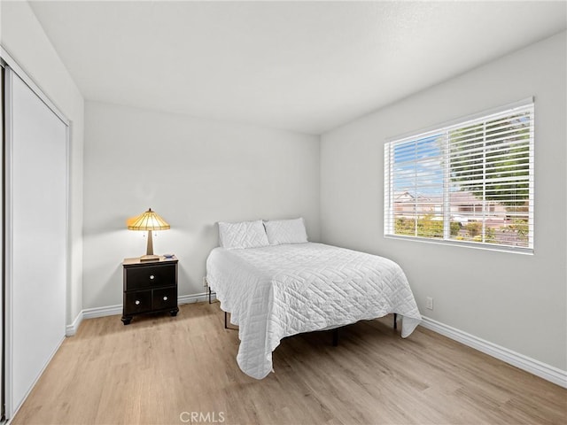 bedroom with baseboards and light wood-style flooring