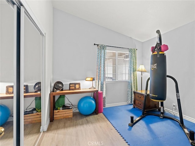 exercise room featuring baseboards, water heater, and lofted ceiling