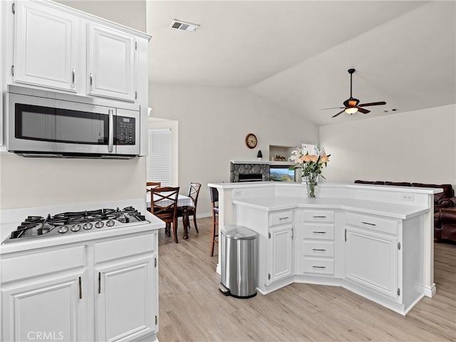 kitchen with a ceiling fan, visible vents, light wood-type flooring, stainless steel appliances, and white cabinetry