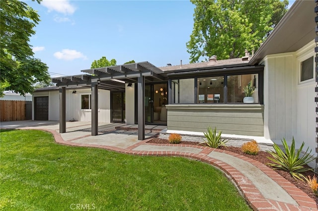 view of front of property featuring a front lawn, fence, a pergola, a patio, and an attached garage