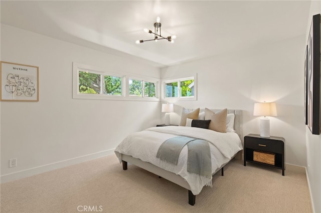 bedroom featuring baseboards, light carpet, and a chandelier