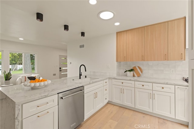 kitchen with stainless steel dishwasher, light stone countertops, a sink, a peninsula, and recessed lighting