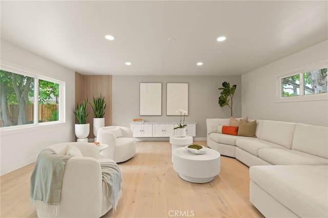 living area featuring recessed lighting, baseboards, and light wood-style flooring