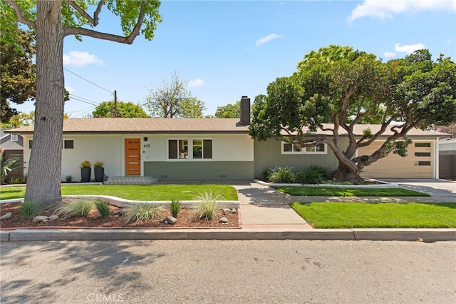 single story home featuring a chimney and a front yard
