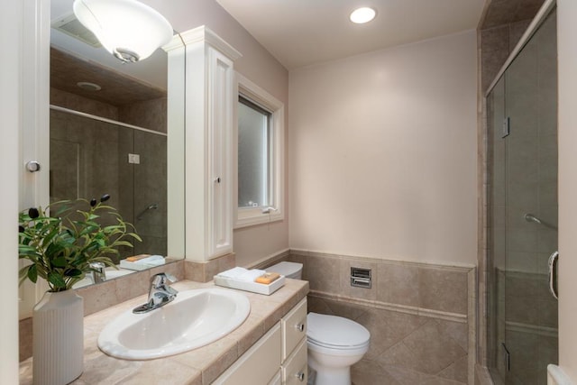 full bathroom featuring toilet, tile walls, a shower stall, and vanity