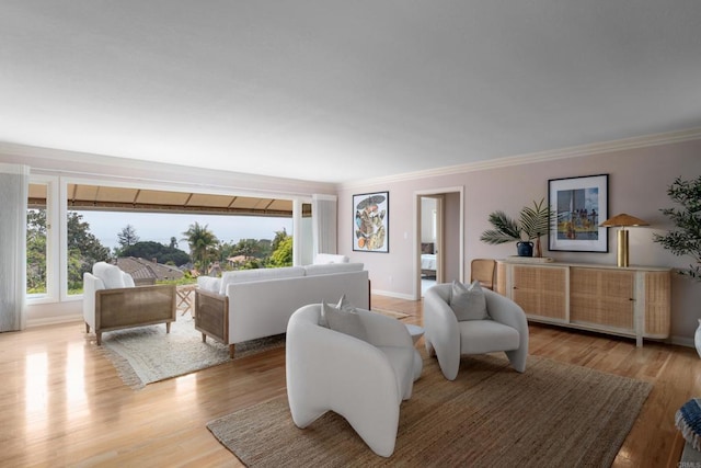 living room with crown molding, light wood-style flooring, and baseboards
