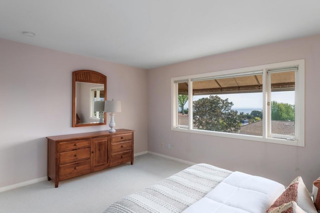 bedroom featuring baseboards and light carpet