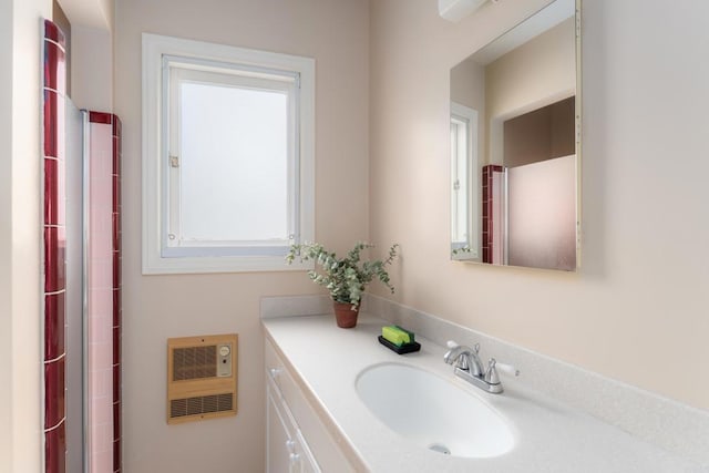 bathroom featuring heating unit and vanity