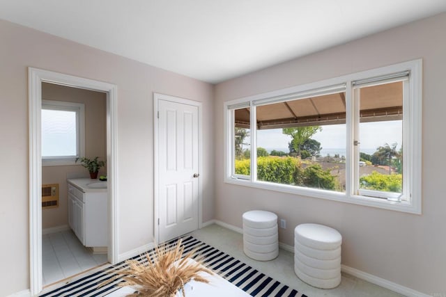 interior space with light tile patterned flooring, baseboards, and a wealth of natural light