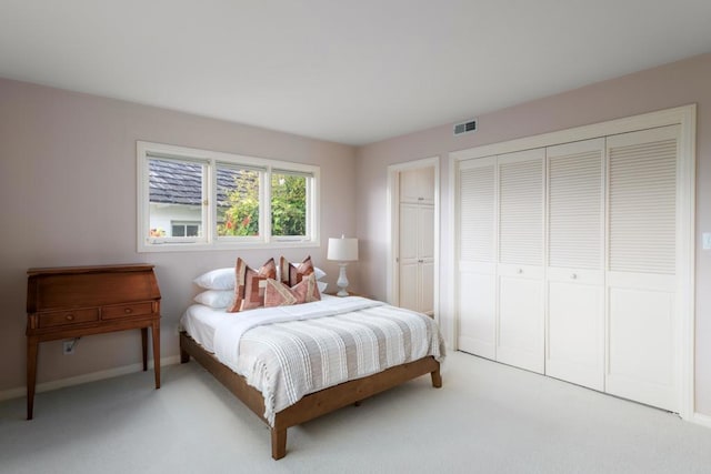 bedroom with light colored carpet, baseboards, visible vents, and a closet