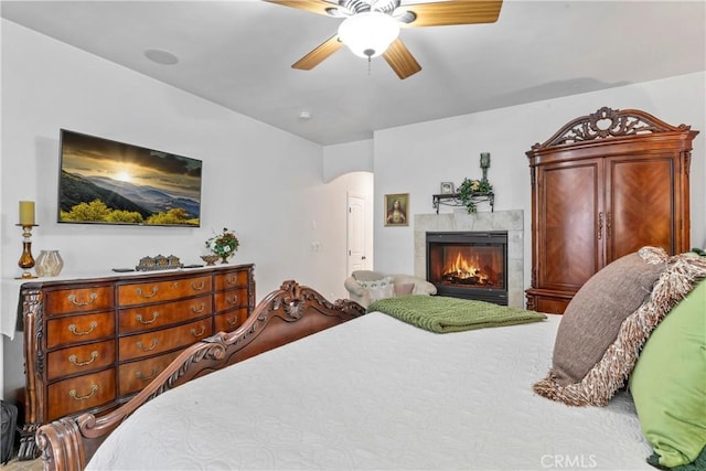 bedroom featuring a ceiling fan and a fireplace