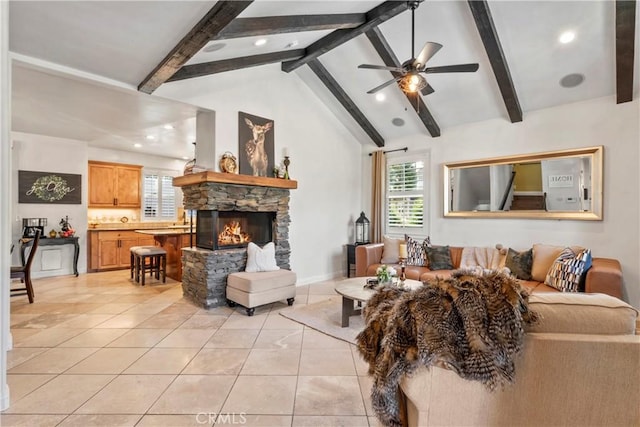 living area featuring plenty of natural light, lofted ceiling with beams, light tile patterned flooring, and a stone fireplace