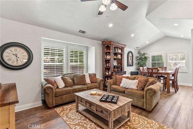 living room featuring ceiling fan, visible vents, vaulted ceiling, baseboards, and hardwood / wood-style floors