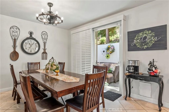 dining space featuring light tile patterned floors, baseboards, and a chandelier