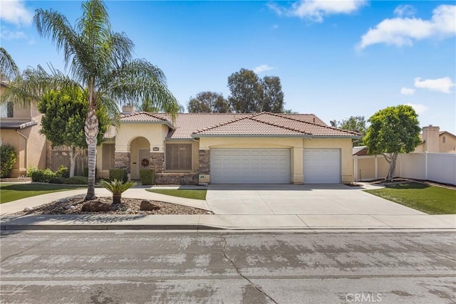 10150 Alta Brisa Way, Moreno Valley, CA 92557 - mediterranean / spanish house featuring stucco siding, stone siding, concrete driveway, a garage, and a tile roof