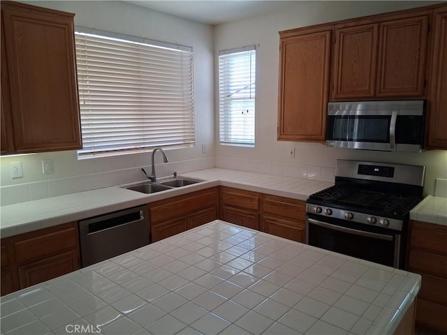 33 Corte Rivera, Lake Elsinore, CA 92532 - kitchen with appliances with stainless steel finishes, a sink, tile countertops, and brown cabinets